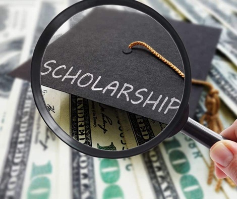 Magnifying glass over a graduation cap with "SCHOLARSHIP" text, surrounded by money.
